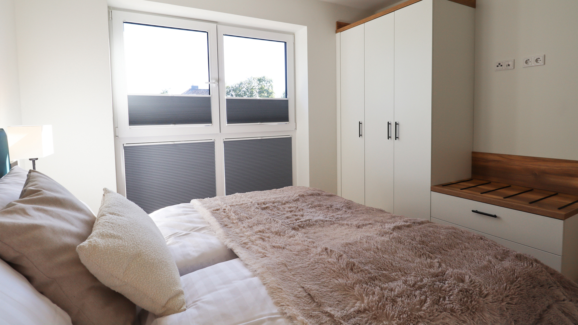 Stilvoll eingerichteter Wohn- und Essbereich der Ferienwohnung Tossens mit gemütlichem Sofa, modernem Esstisch und harmonischem Raumkonzept.